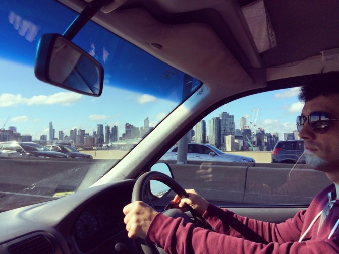 Campervan interior with driver and Melbourne city skyline
