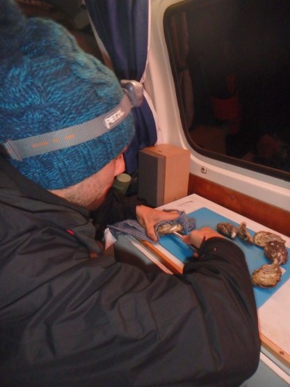 Gareth shucking oysters in the van