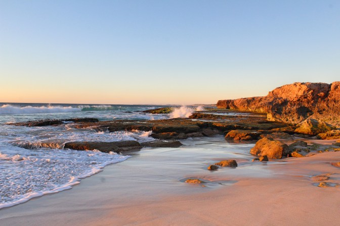 Sunset on rocky beach Red Bluff Western Australia